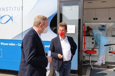 Im Gespräch mit Landrat Dr. Neth. Im Hintergrund der Bus des RKI